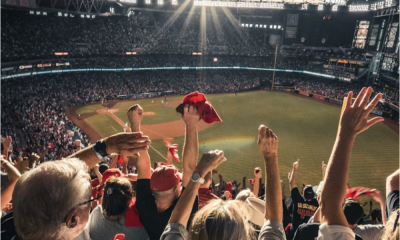 A crowd of enthusiastic fans cheering and waving red towels at a baseball game