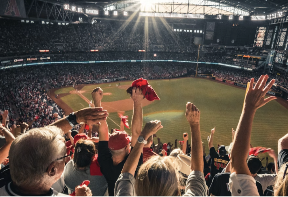 A crowd of enthusiastic fans cheering and waving red towels at a baseball game