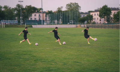 Amateur footballers training on a grass pitch in the morning light