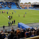 Post-match scene at Brunton Park showing Carlisle players, staff and supporters on the pitch and in the stands after a heavy defeat