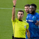 Referee raises his arm beside Oldham players during the Oldham Athletic vs Salford City match.