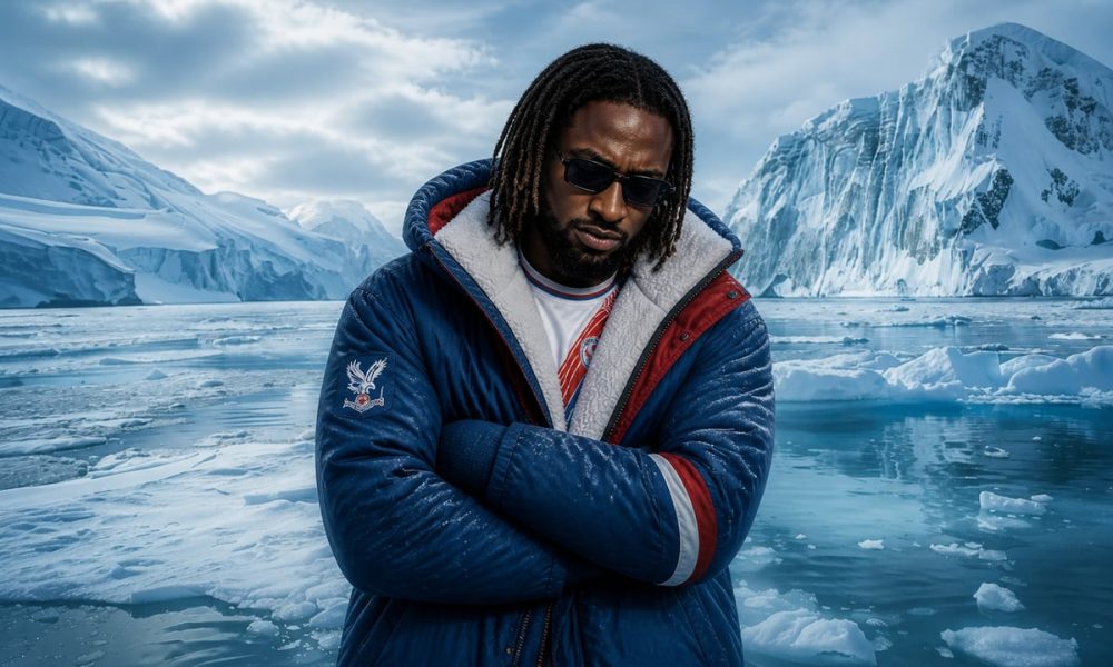 A person wearing Crystal Palace outerwear with folded arms, posed against an icy, mountainous seascape.