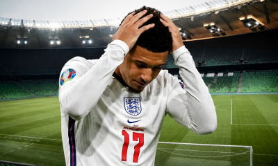 Jadon Sancho wearing number 17, hands on his head in a near-empty stadium